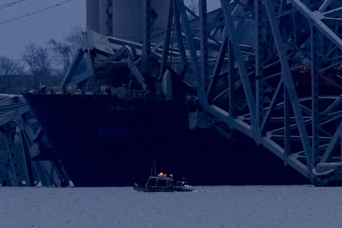 Un buque portacontenedores reposa contra los restos del puente Francis Scott Key mientras cae l ...
