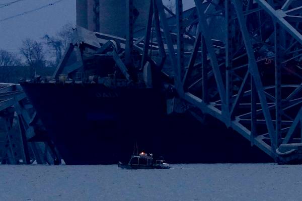 Un buque portacontenedores reposa contra los restos del puente Francis Scott Key mientras cae l ...