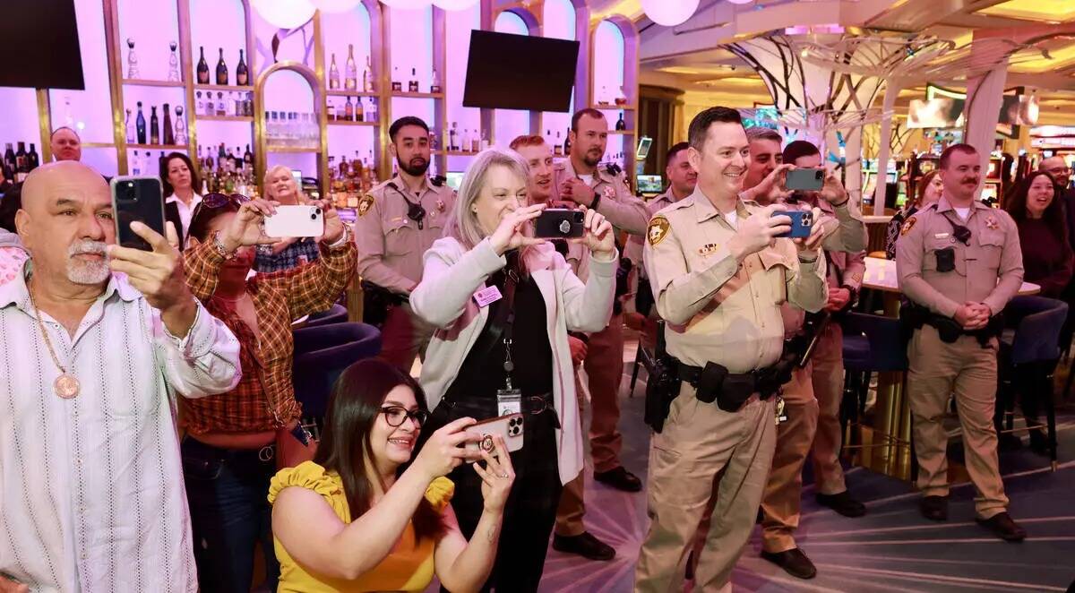 Familiares y compañeros de trabajo toman fotos mientras los oficiales de policía de Las Vegas ...
