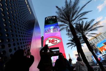 Aficionados al fútbol americano fotografían una marquesina del Super Bowl en Aria, el sábado ...