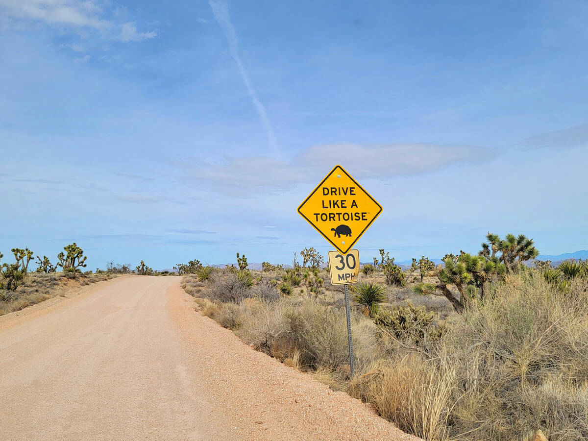 Un letrero de tráfico recomienda conducir con precaución por la carretera Walking Box Ranch, ...
