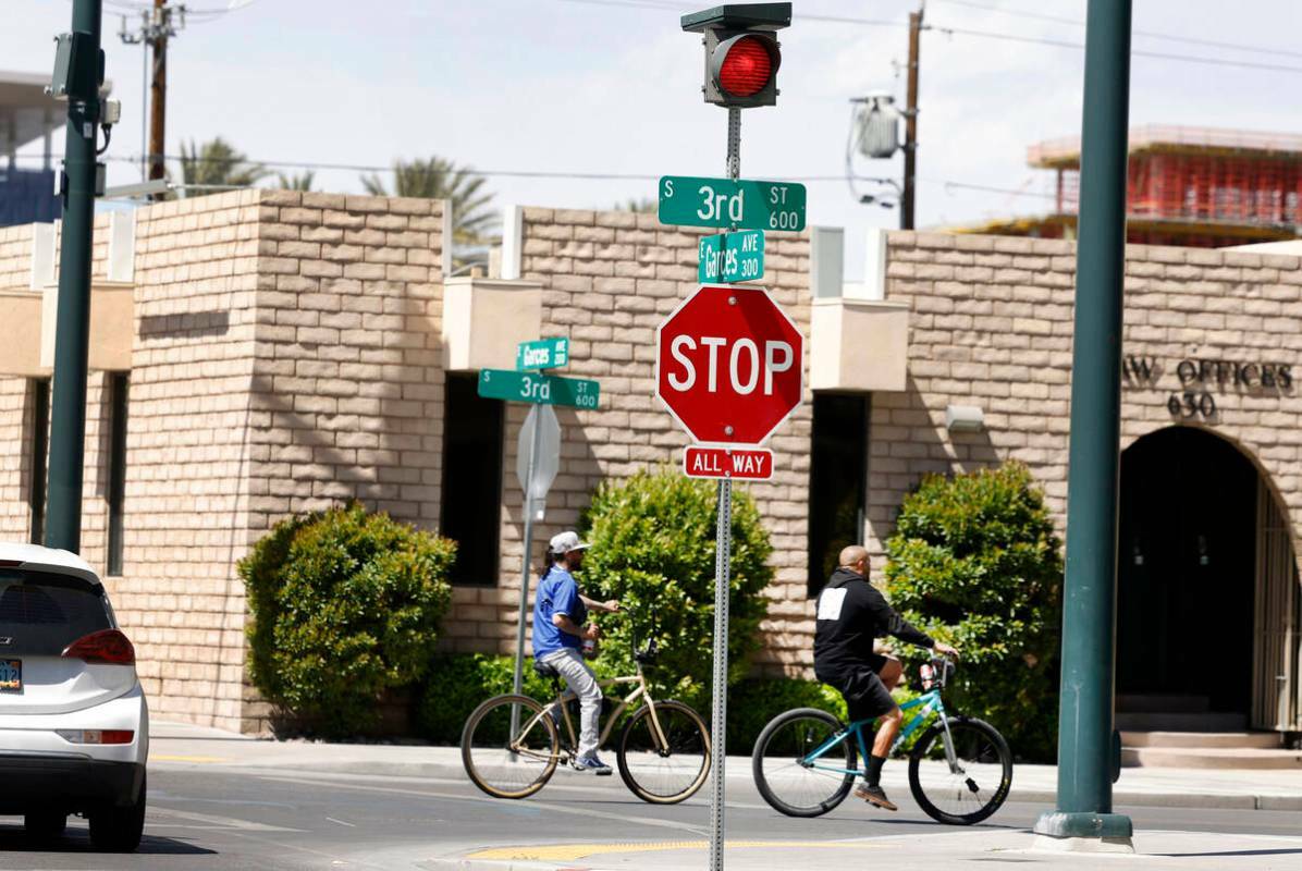 Ciclistas pasan junto al semáforos añadido recientemente en la intersección de Third Street ...