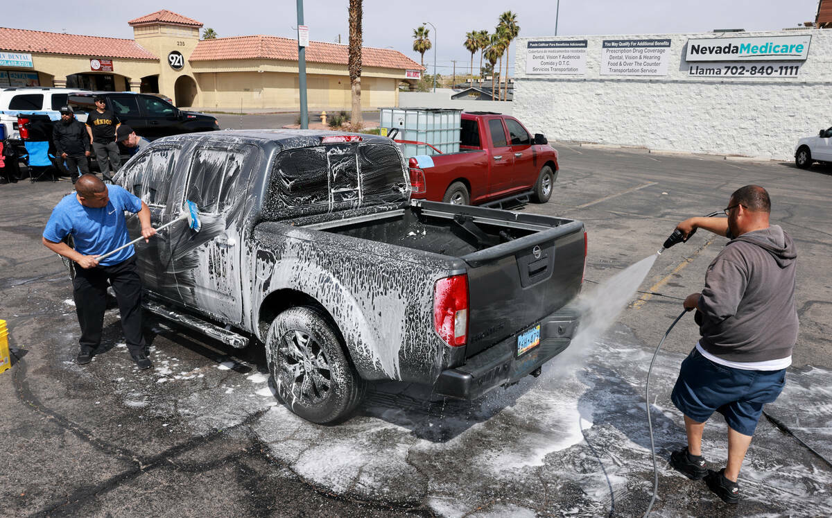Juan Sandoval, izquierda, y José Tejeda lavan una camioneta durante una recaudación de fondos ...
