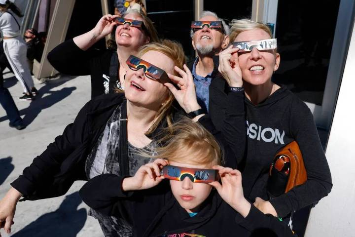 Sandra Callies, centro izquierda, y su esposo, Gerard, centro atrás, observan un eclipse solar ...