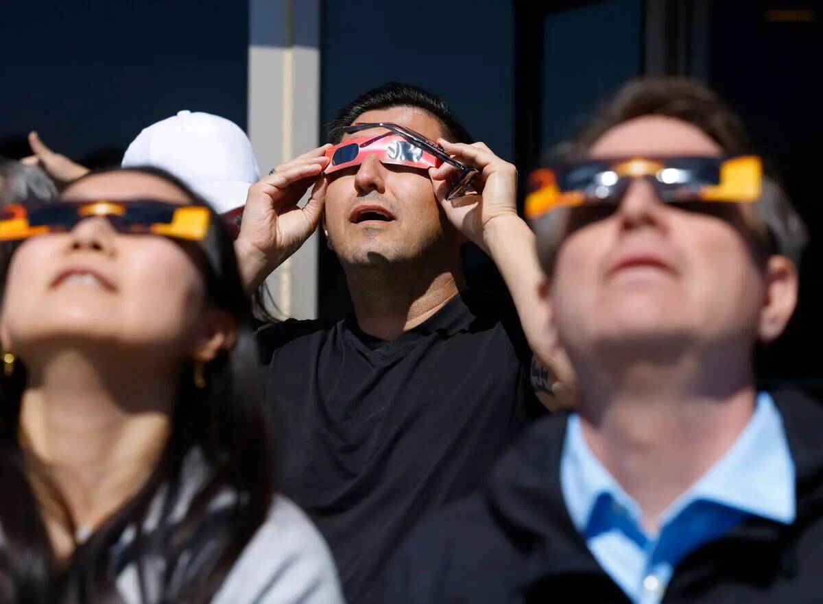 La gente ve un eclipse solar parcial en la plataforma de observación en The Strat, el lunes 8 ...