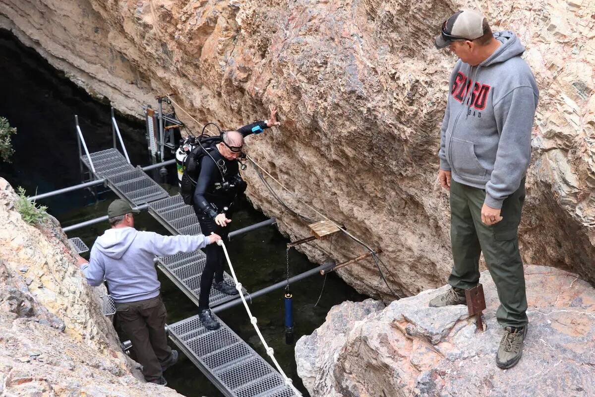 Maloney, buceador de cuevas y voluntario del Death Valley National Park, en el centro, sale del ...