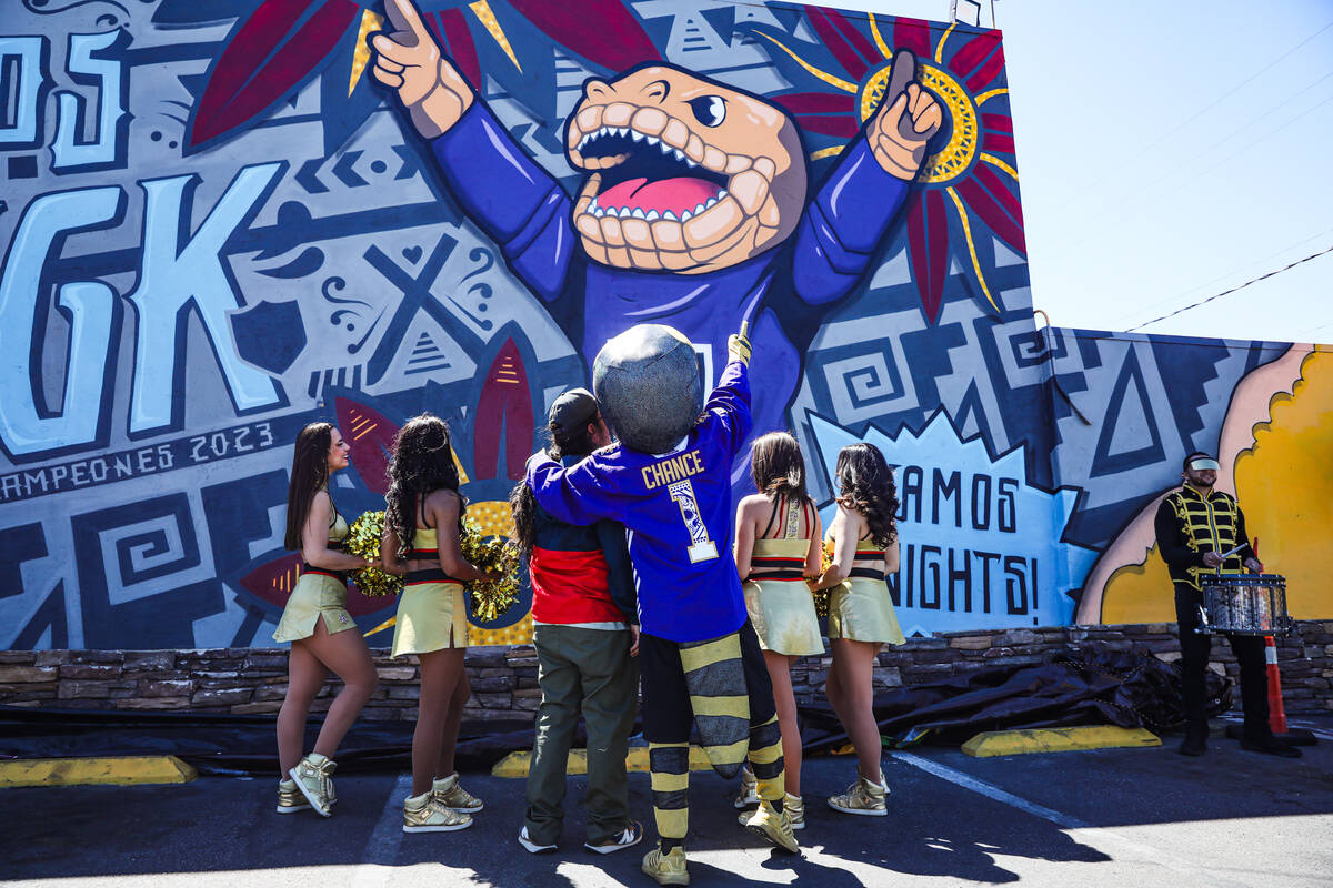 La mascota de los Golden Knights, Chance, abraza al artista Anthony Ortega mientras ven el mura ...