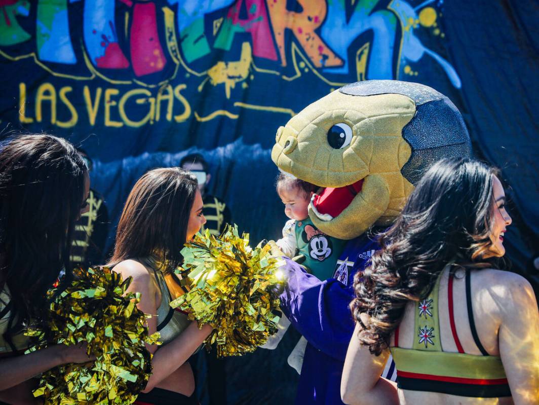 La mascota de los Golden Knights, Chance, sostiene a Jeydi Páez, de 4 meses, rodeada de Vegas ...