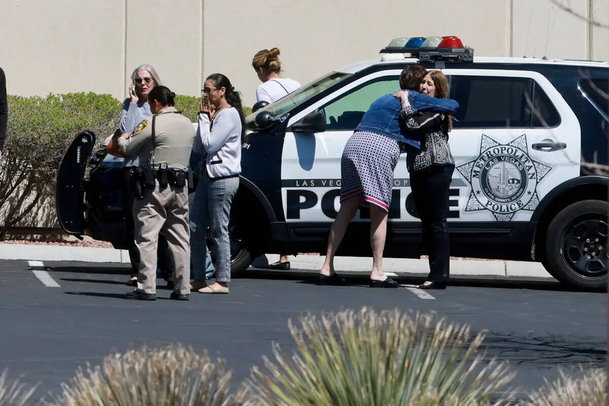 Varias personas se abrazan mientras esperan a la policía de Las Vegas que investiga un tiroteo ...