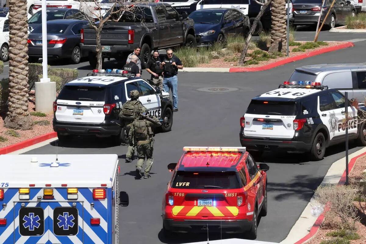 La policía de Las Vegas con un ariete y una palanca corre hacia el City National Bank Building ...