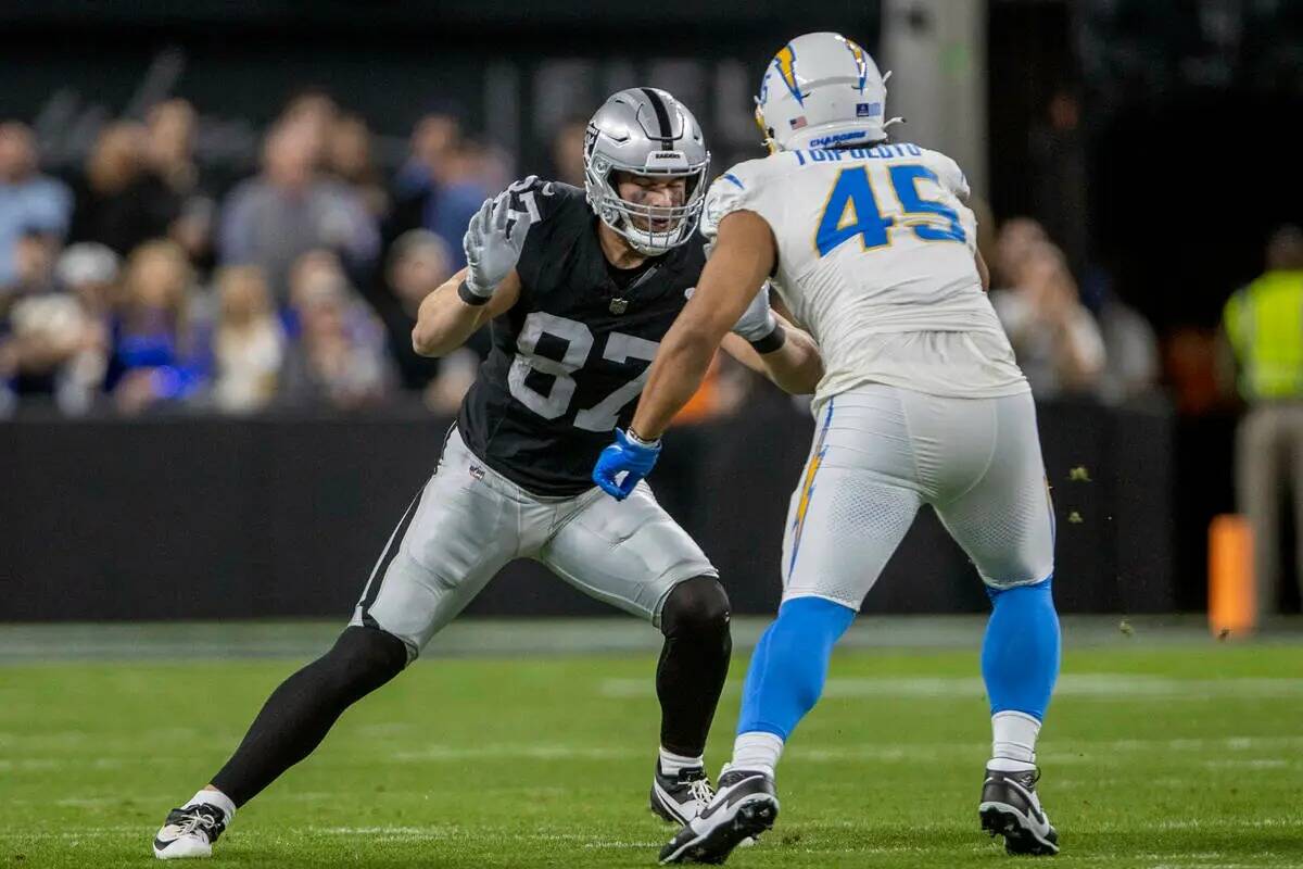 El tight end de los Raiders Michael Mayer (87) bloquea al linebacker de Los Angeles Chargers Tu ...