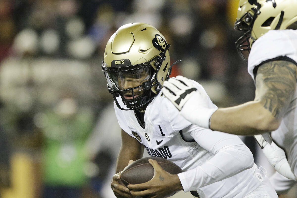 El quarterback de Colorado, Shedeur Sanders, en el centro, lleva el balón durante la primera m ...