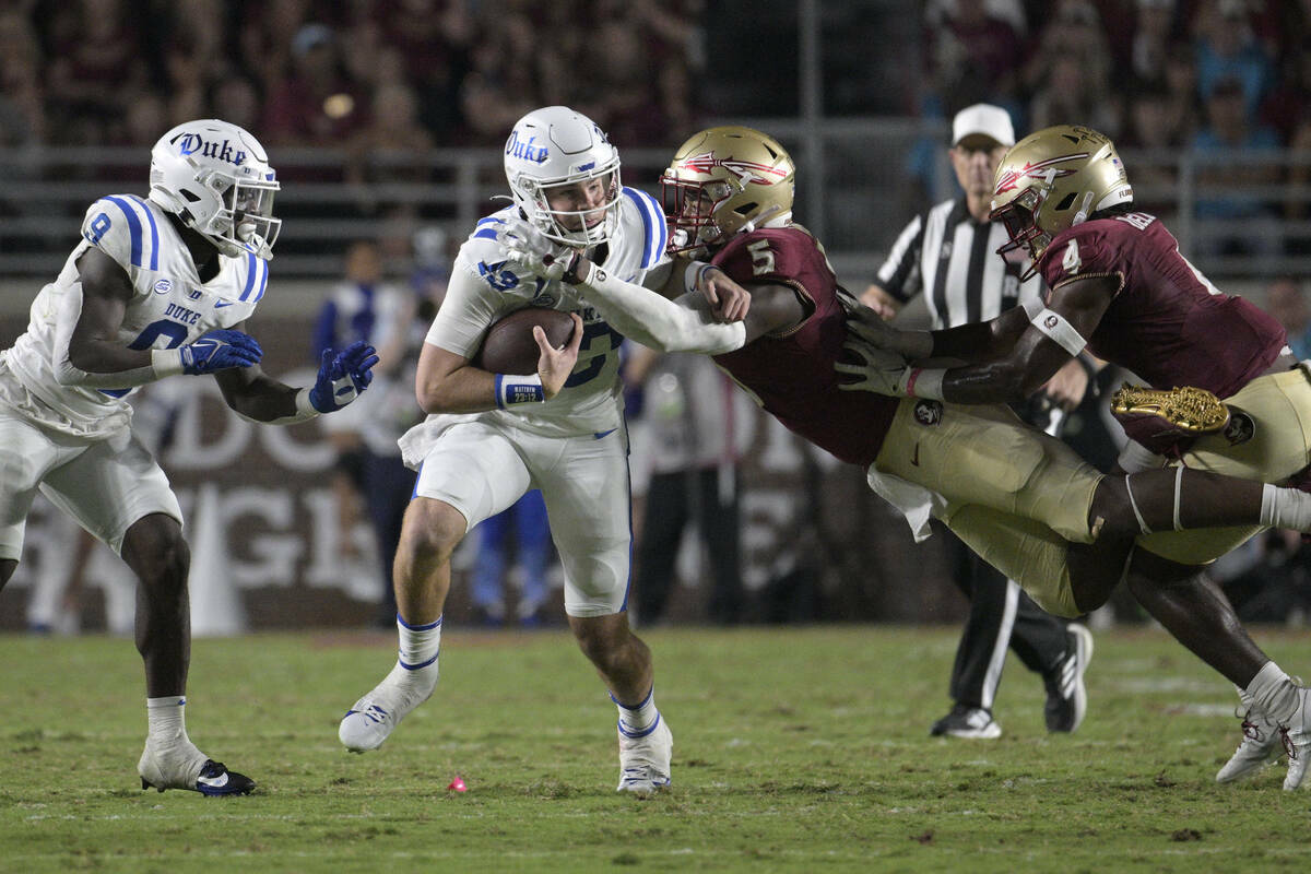 El quarterback de Duke, Riley Leonard (13), es tacleado por el defensive lineman de Florida Sta ...