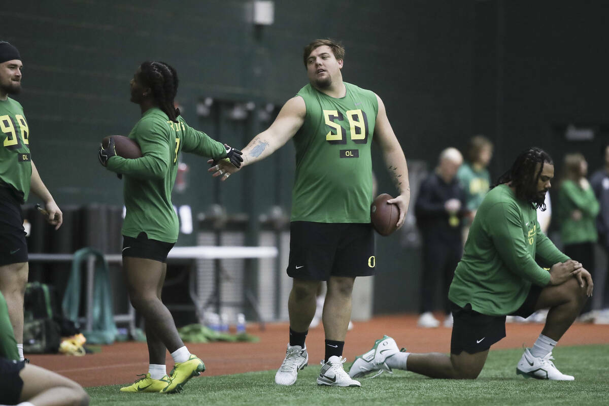 El running back de Oregon Bucky Irving, a la izquierda, choca las palmas con el offensive linem ...