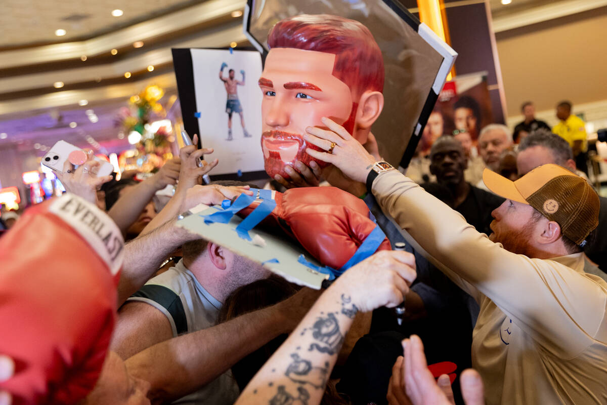 Canelo Álvarez llega a firmar una imagen de su cabeza para un fan después de llegar al MGM Gr ...