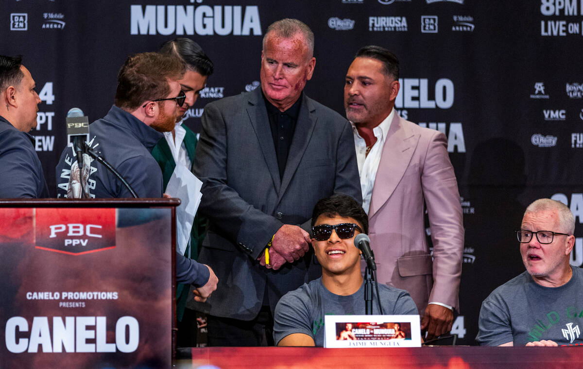 El boxeador 'Canelo' Álvarez intercambia palabras con su expromotor Óscar De La Hoya durante ...
