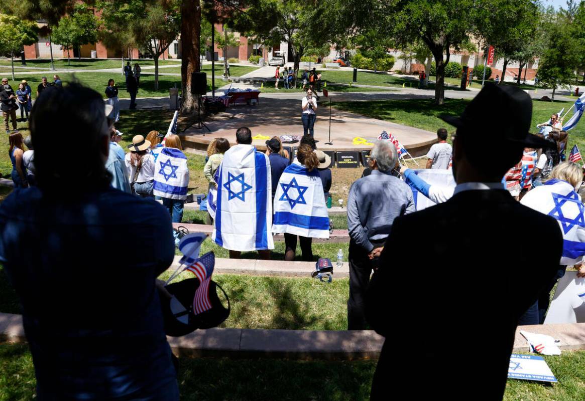 Personas se ponen de pie durante el himno nacional de Israel durante la manifestación Stand Ag ...