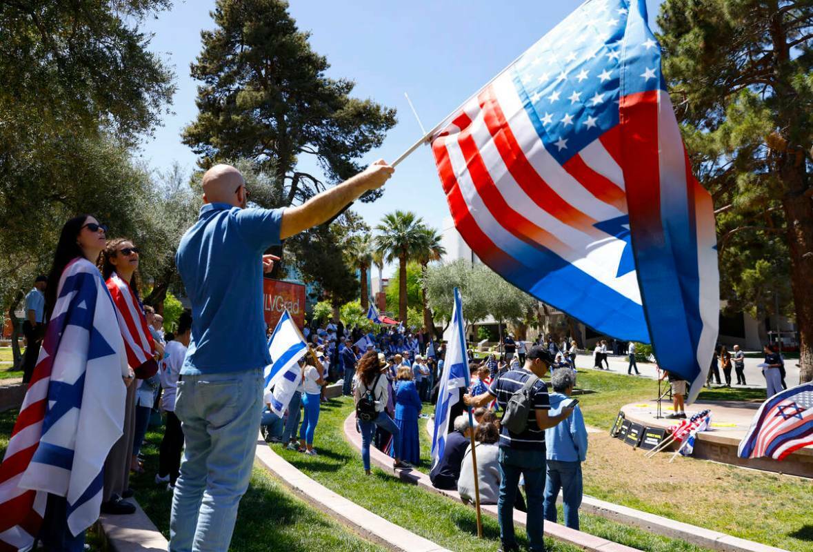 Ilan Sander ondea las banderas de EEUU e Israel durante la manifestación Stand Against Hate en ...