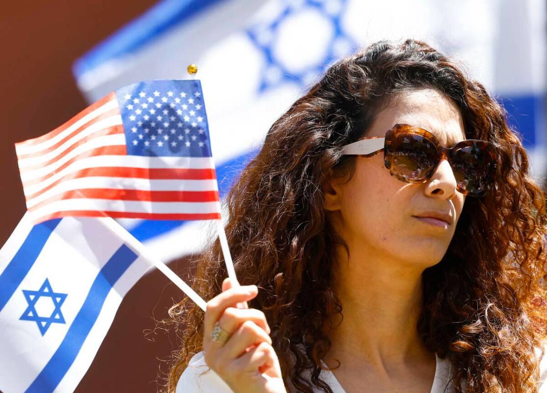 Anat Meged-Nisgoda sostiene banderas de EEUU e Israel mientras asiste a la manifestación Stand ...