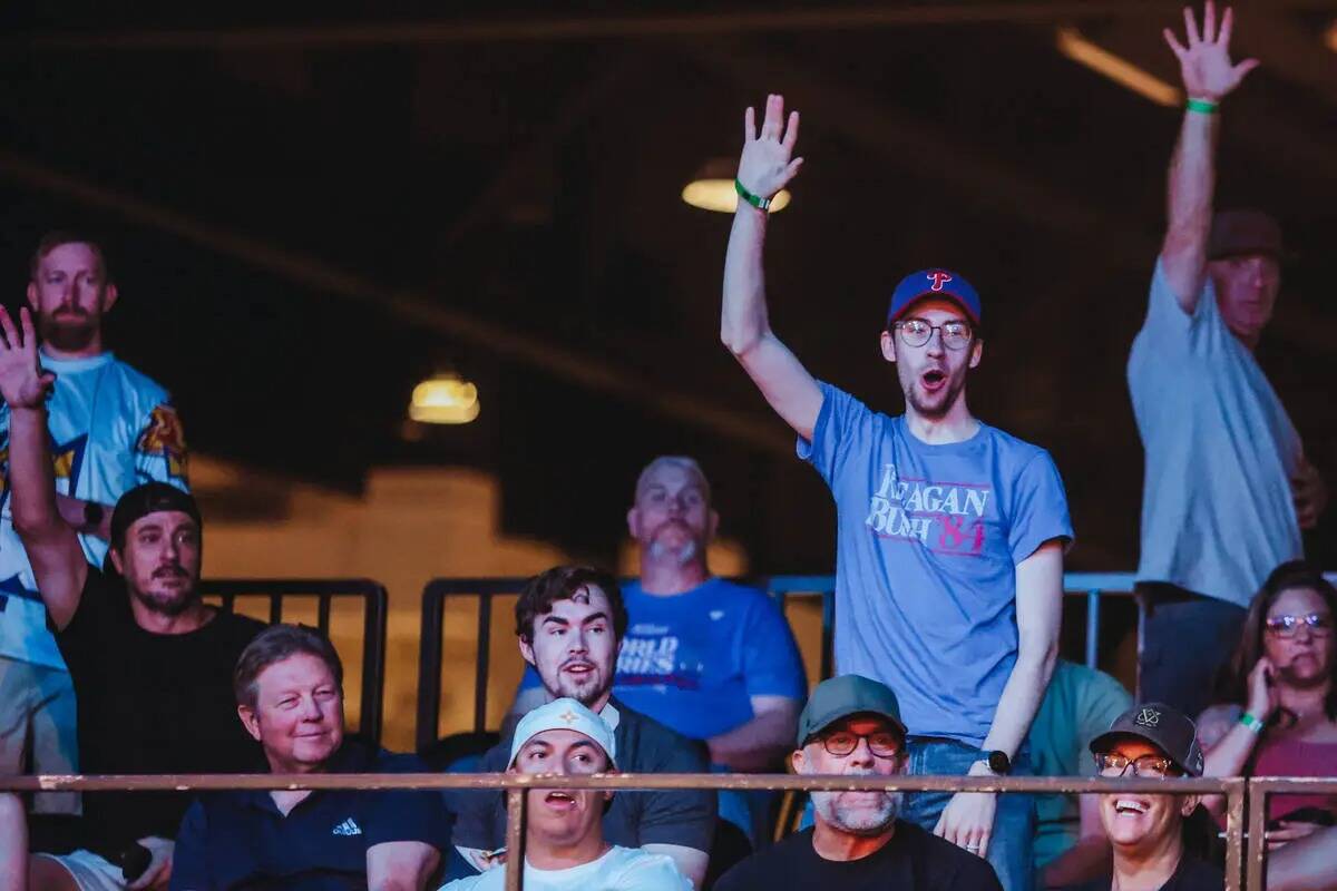 Los fans del público animan para conseguir una camiseta gratis durante un partido de cornhole ...