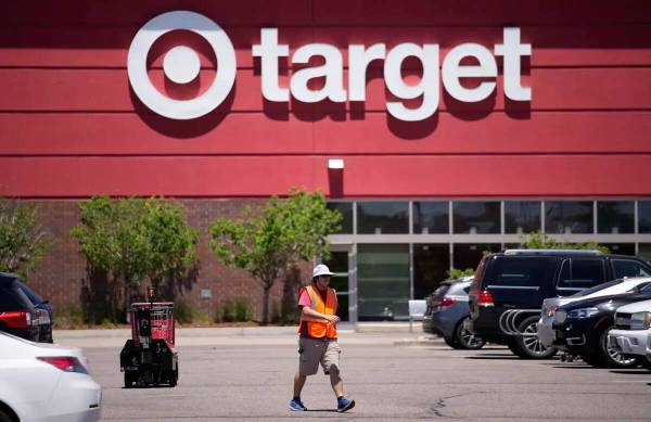 Un trabajador recoge carritos de la compra en el estacionamiento de una tienda Target el 9 de j ...
