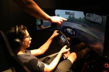 Un entrenador del simulador de McLaren ayuda a Joseph Launi, de visita desde Toronto, Canadá p ...