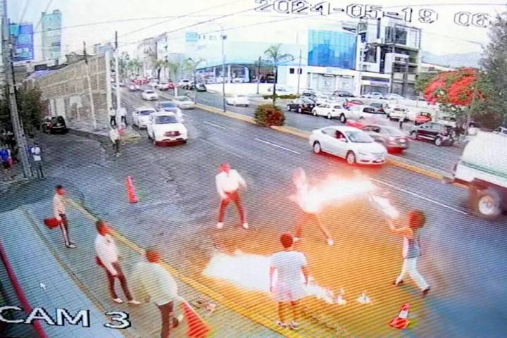 En esta imagen tomada de un video proporcionado por Jorge Toscano, un tragafuegos, a la derecha ...