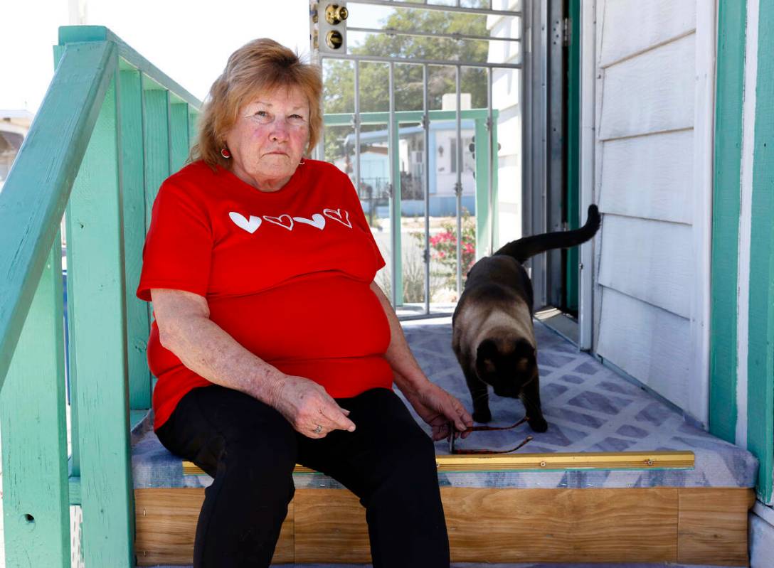 Risa Sykes posa con su gato, Hyme, delante de su casa móvil en Palm Grove Senior Mobile Home P ...