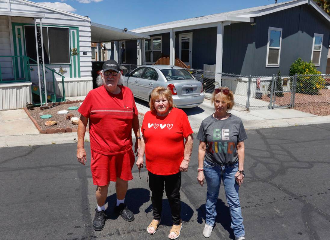 James Hatland posa con Risa Sykes, en el centro, y Wendy Nelson delante de las casas móviles d ...