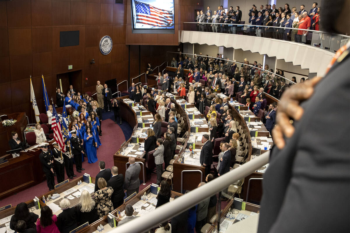 Los legisladores de pie para el juramento de lealtad como la Asamblea se reúnen para el primer ...