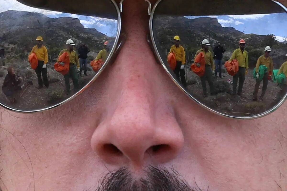 Los bomberos de la Oficina de Gestión de Tierras se reflejan en las gafas de sol de Andrew Mer ...