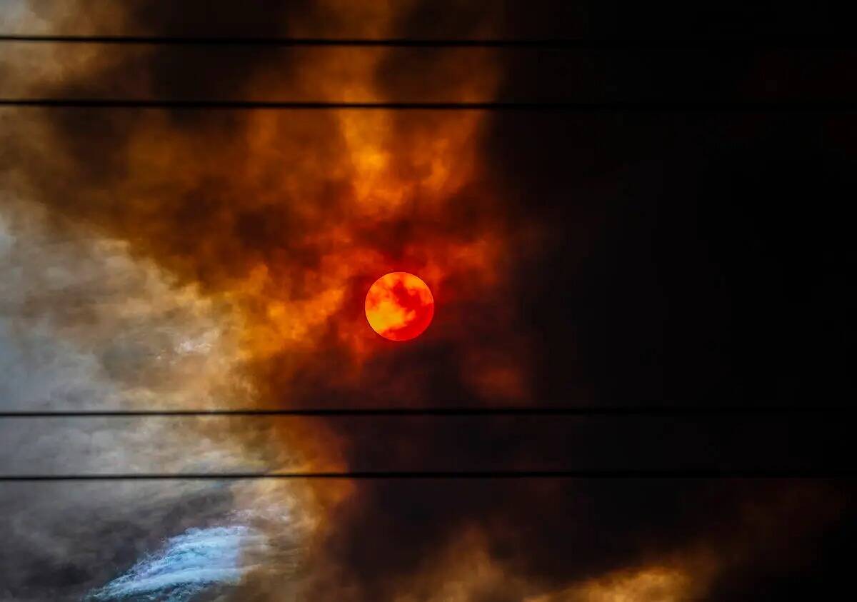 El sol está cubierto de humo rojo originado por el incendio Mahogany Fire cerca de Mount Charl ...