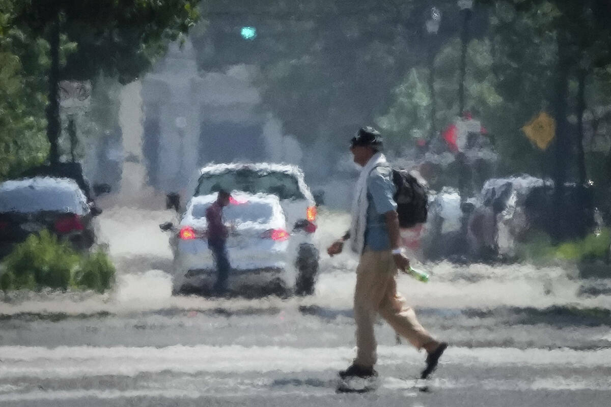 Una persona cruza Caroline Street bajo el calor de la tarde del sábado 25 de mayo de 2024, cer ...