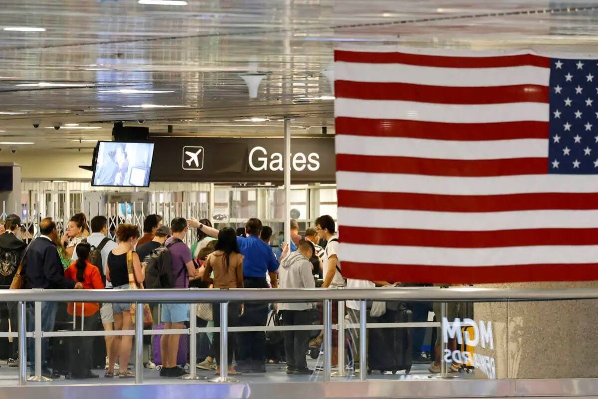 Pasajeros esperan en fila para pasar el control de seguridad en la Terminal 1 del Aeropuerto In ...