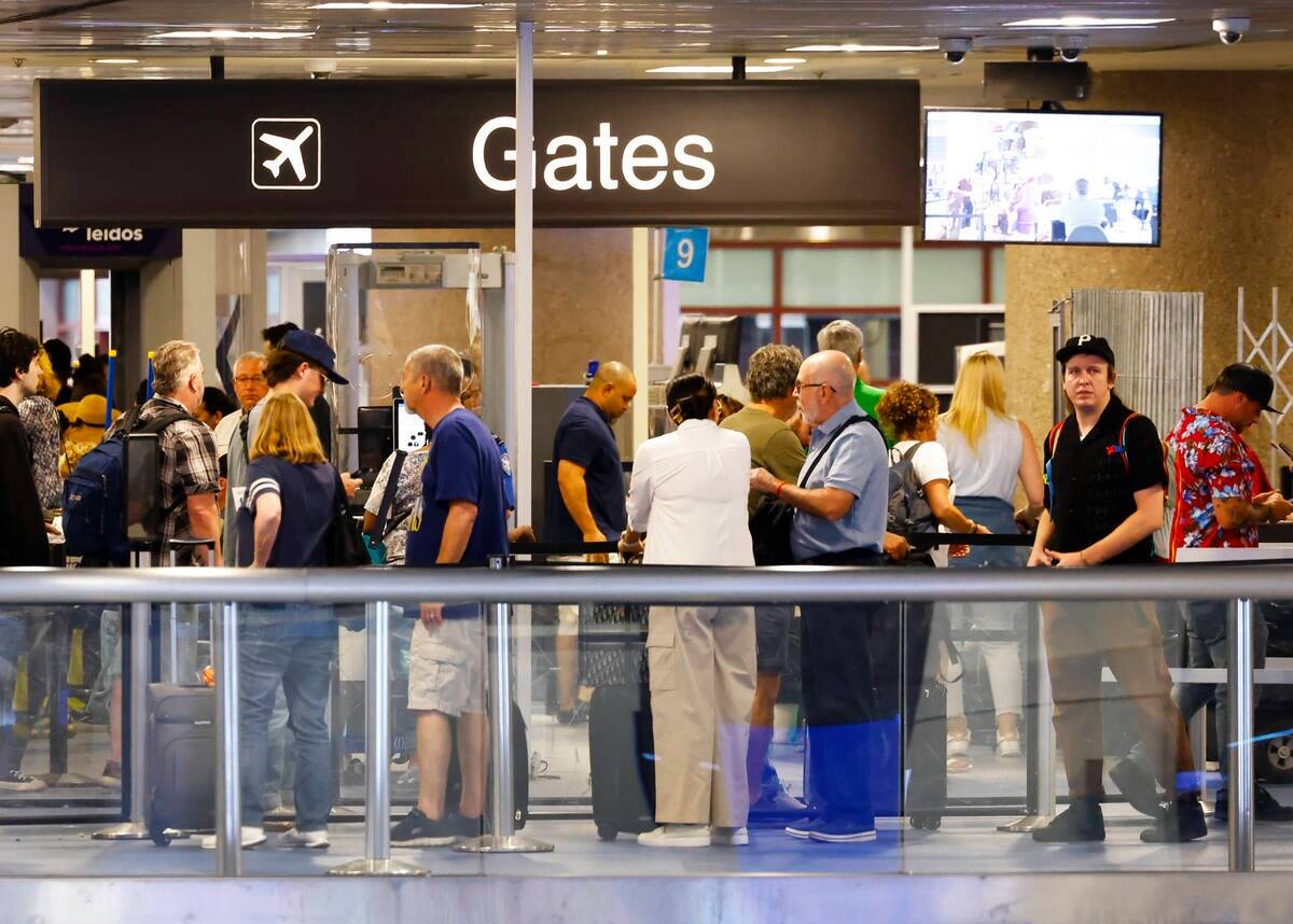 Pasajeros esperan en fila para pasar el control de seguridad en la Terminal 1 del Aeropuerto In ...