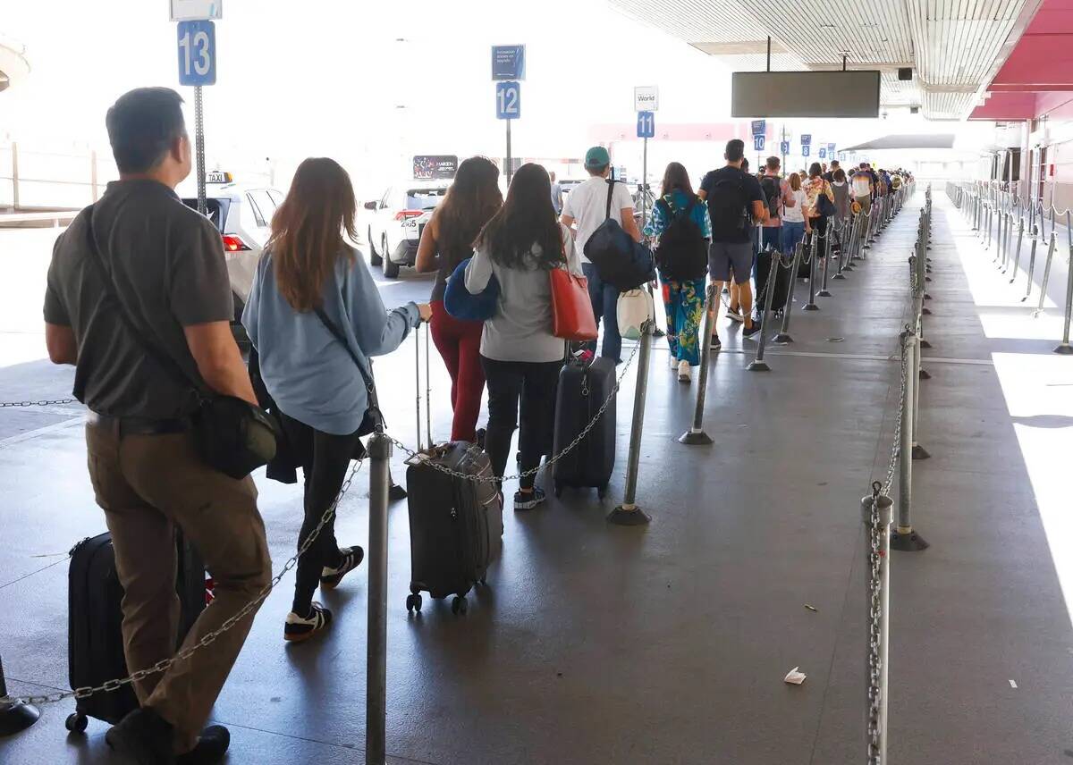 Los pasajeros que llegan al Aeropuerto Internacional Harry Reid esperan en fila para tomar un t ...