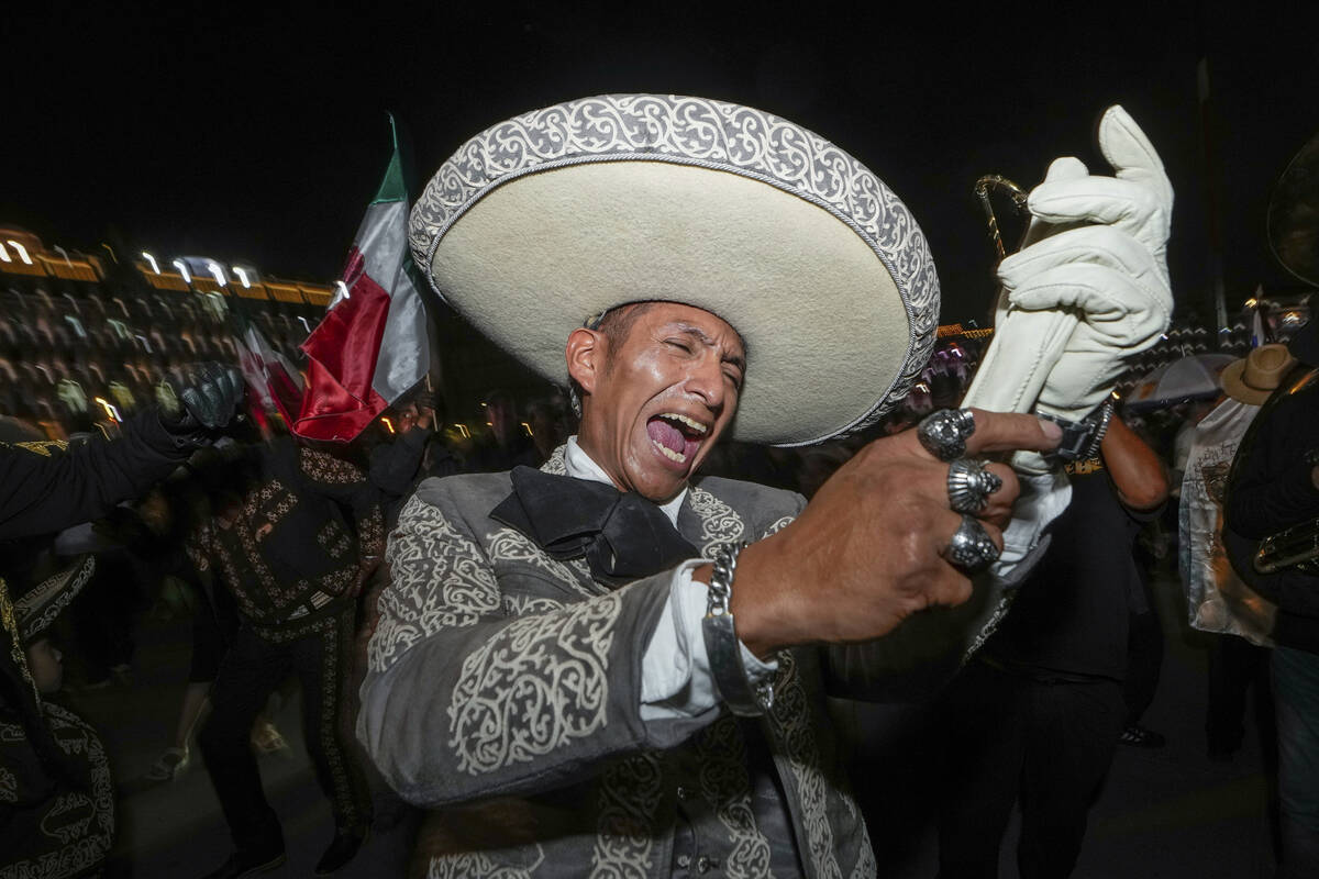 Un hombre vestido con ropa de mariachi canta después del cierre de las urnas durante las elecc ...