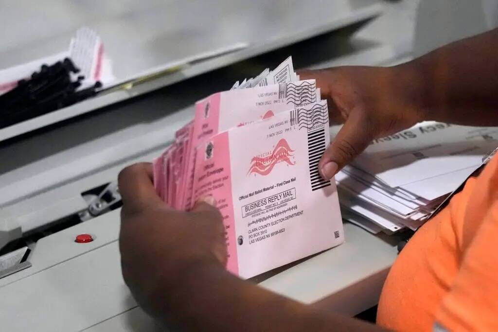 ARCHIVO - Un trabajador electoral prepara los votos por correo en el Departamento Electoral del ...