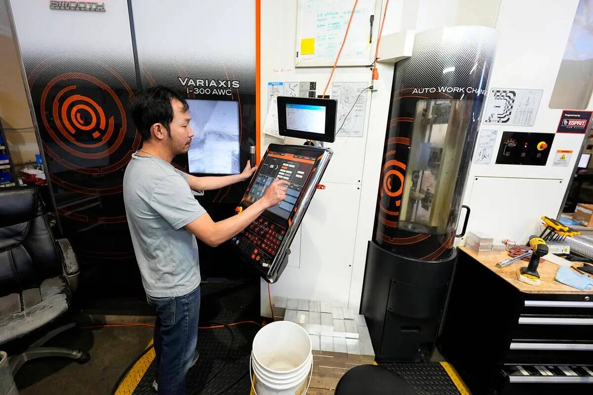ARCHIVO - Un trabajador de Reata Engineering and Machine Works programa una máquina Mazak Vari ...