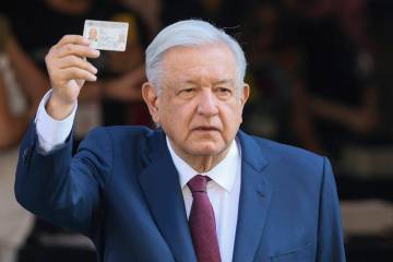 El presidente saliente Andrés Manuel López Obrador muestra su identificación después de vot ...