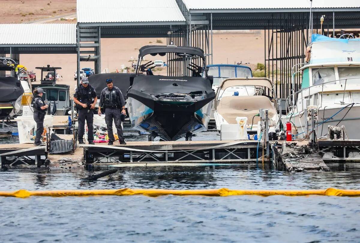 Funcionarios en la escena donde un incendio hundió 10 barcos, causó daños a varios más y le ...