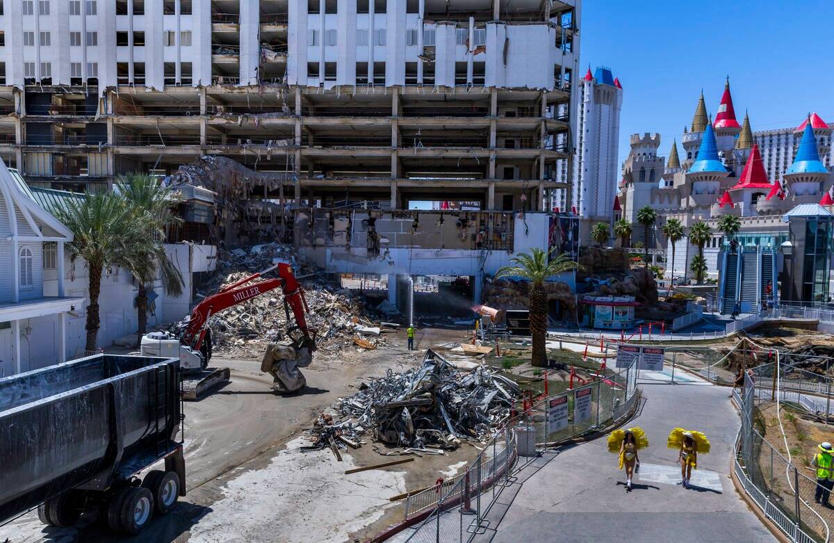 Coristas llevan hidratación al pasar por la demolición del Tropicana mientras los trabajadore ...