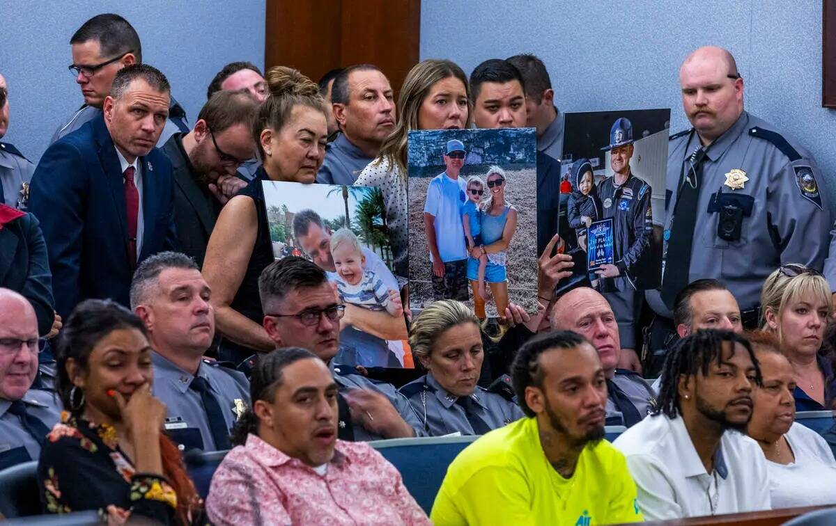 Simpatizantes sostienen fotos de la familia del policía de Nevada Highway Patrol Michael Abbat ...