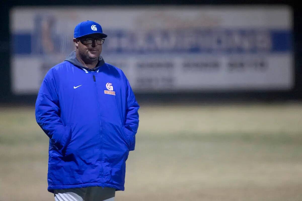 El entrenador principal de Bishop Gorman, Chris Sheff, observa desde la tercera base durante un ...