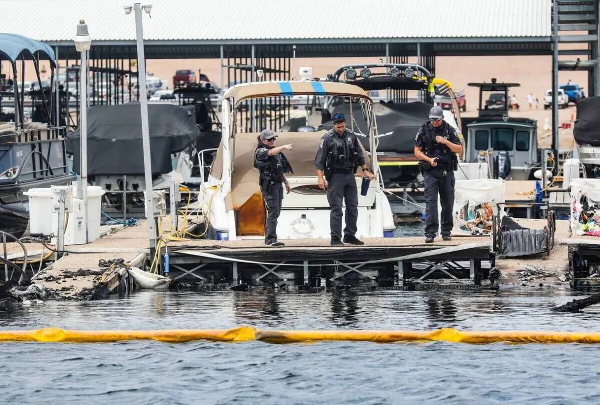 Funcionarios en la escena donde un incendio hundió 10 barcos, causó daños a varios más y ca ...