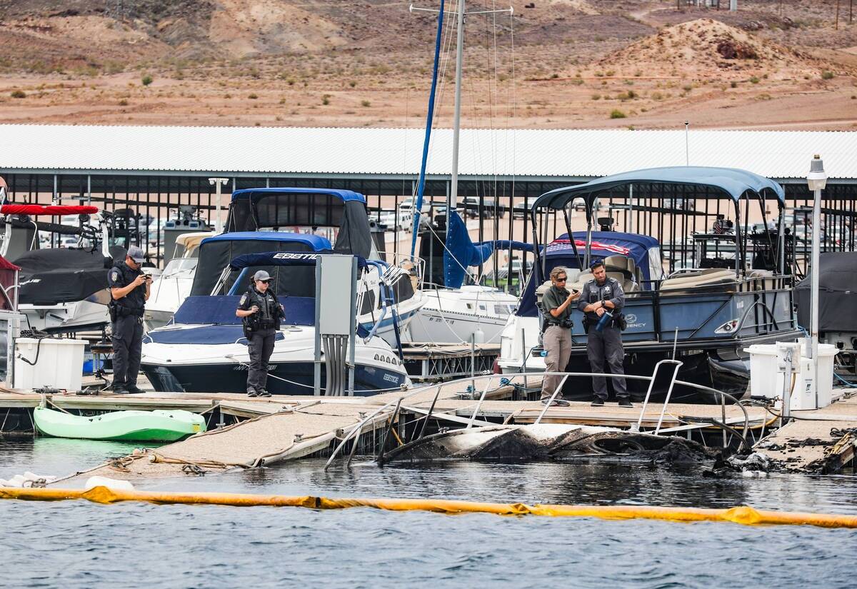 Funcionarios en la escena donde un incendio hundió 10 barcos, causó daños a varios más y le ...