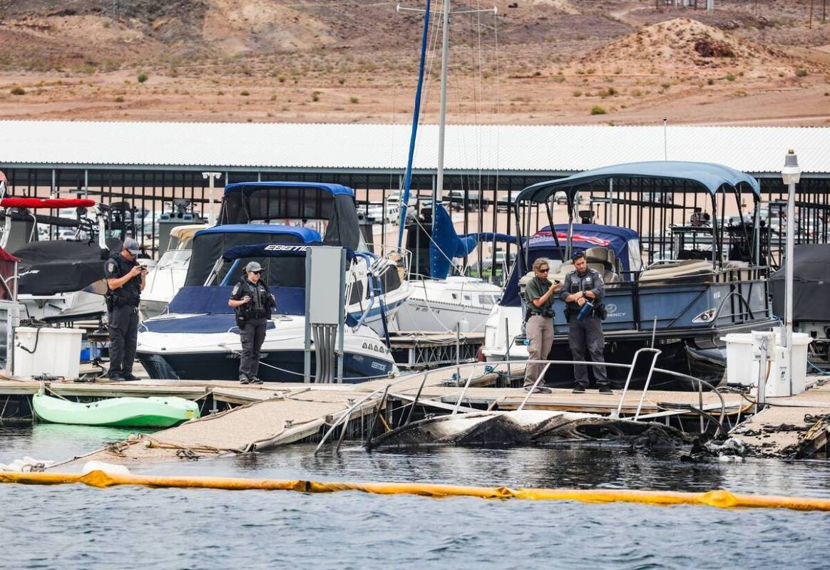 Funcionarios en la escena donde un incendio hundió 10 barcos, causó daños a varios más y le ...