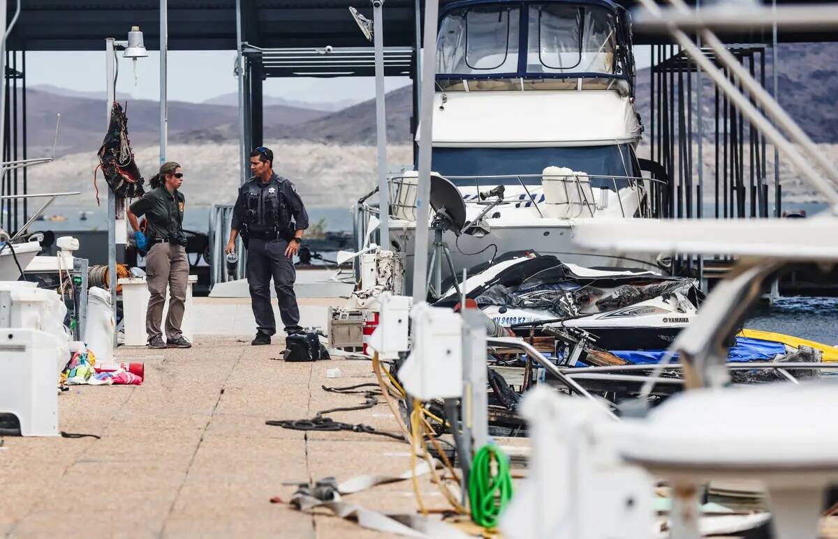 Funcionarios en la escena donde un incendio hundió 10 barcos, causó daños a varios más y le ...