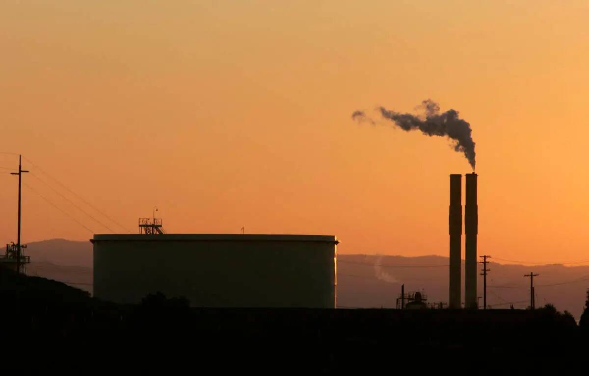 Una refinería de petróleo se ve en 2006 al atardecer en Rodeo, California (AP Photo/Rich Pedr ...