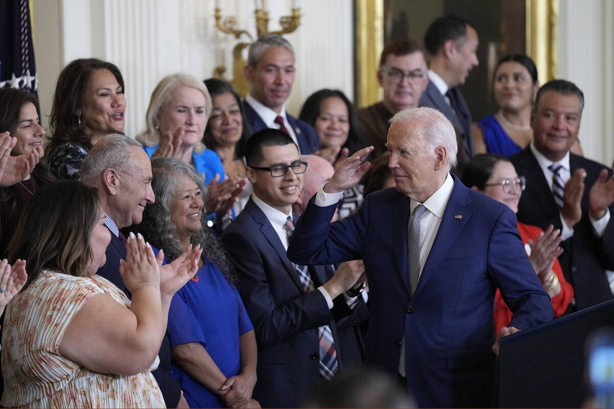 President Joe Biden turns to the others on the dais after speaking during an event marking the ...